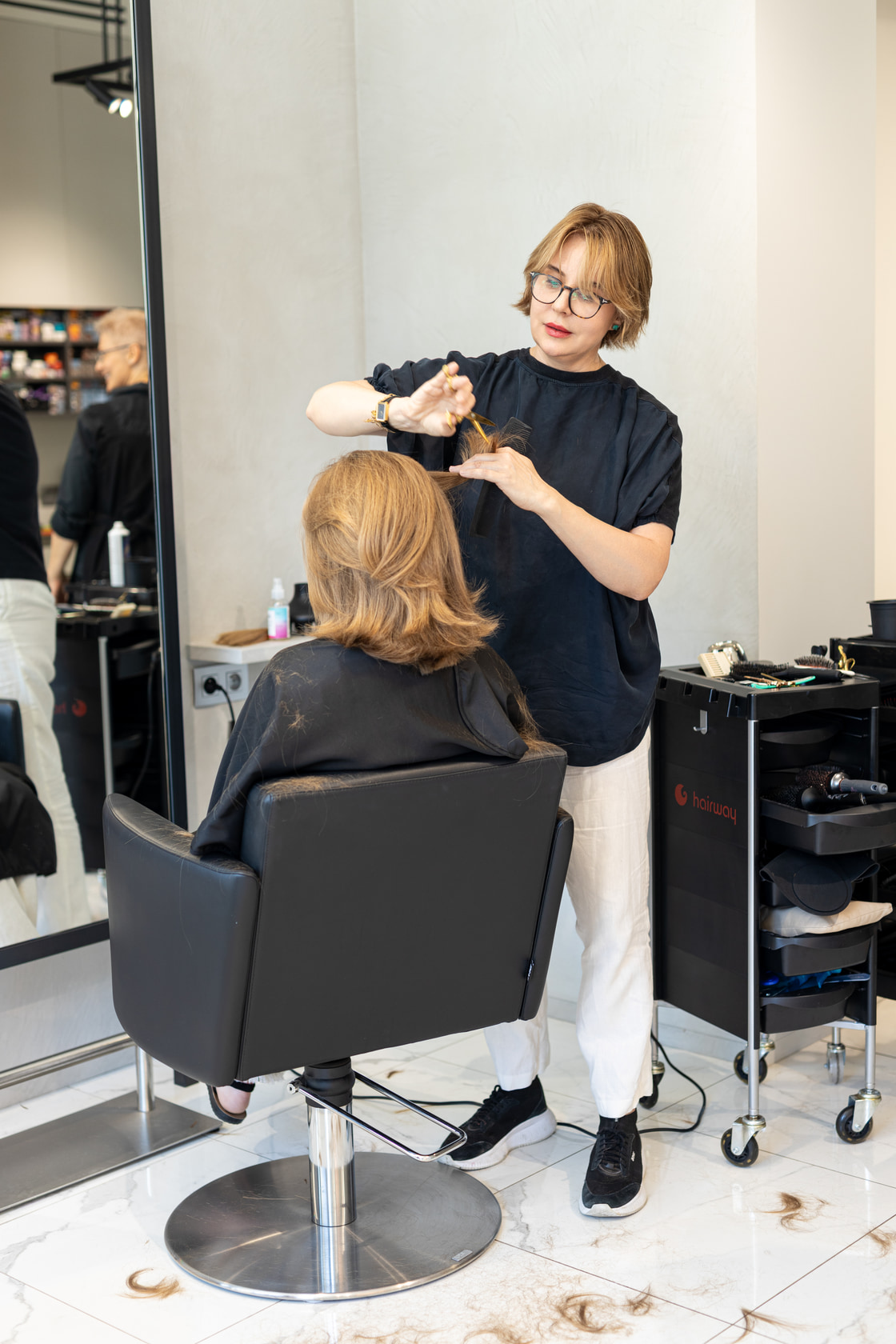 Vue d’ensemble du salon avec une coiffeuse au travail