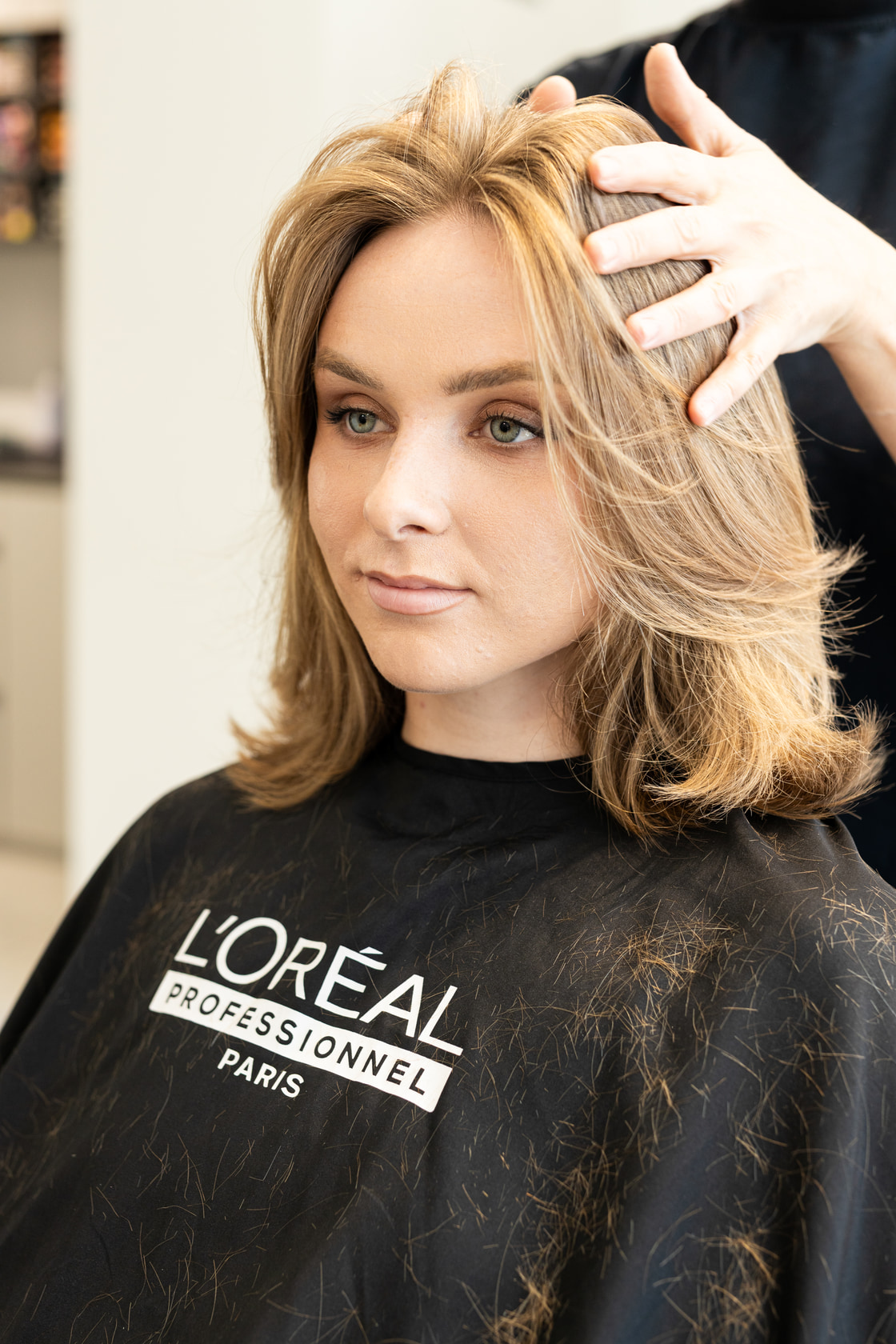 Cliente en peignoir après le brushing, regard vers l’objectif